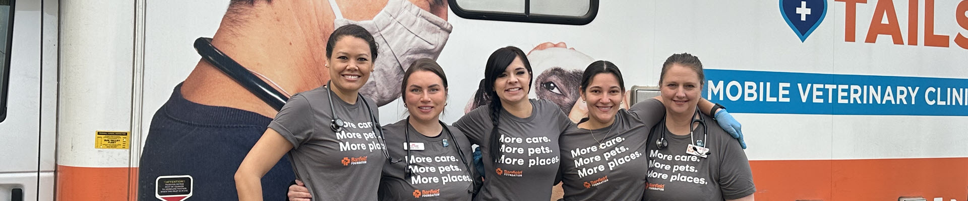 5 Banfield Associates standing in front of a Banfield Mobile Van